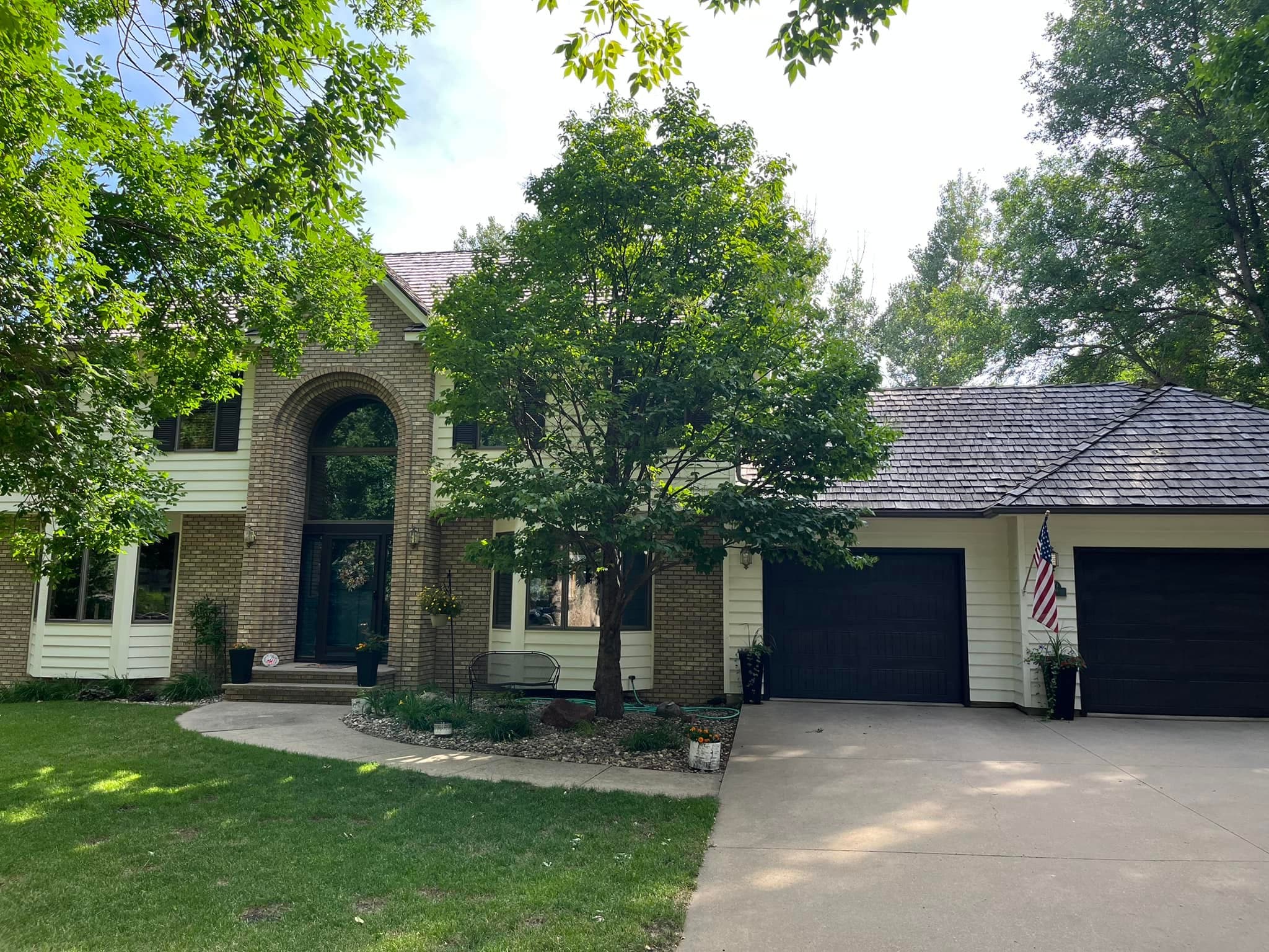 A brick home entry with an arched window and tidy landscaping
