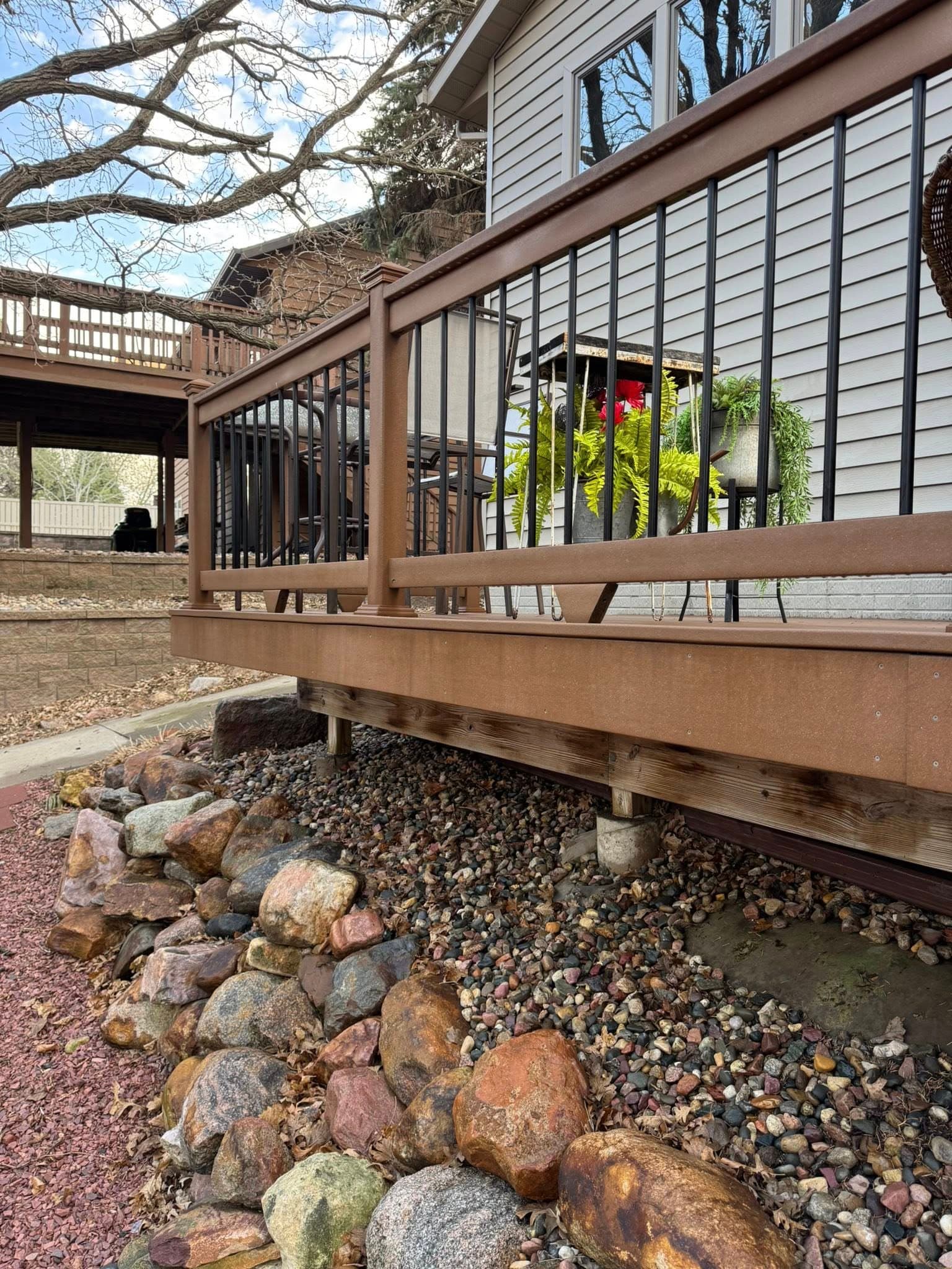 A clean deck railing over a rock bed at a home exterior job
