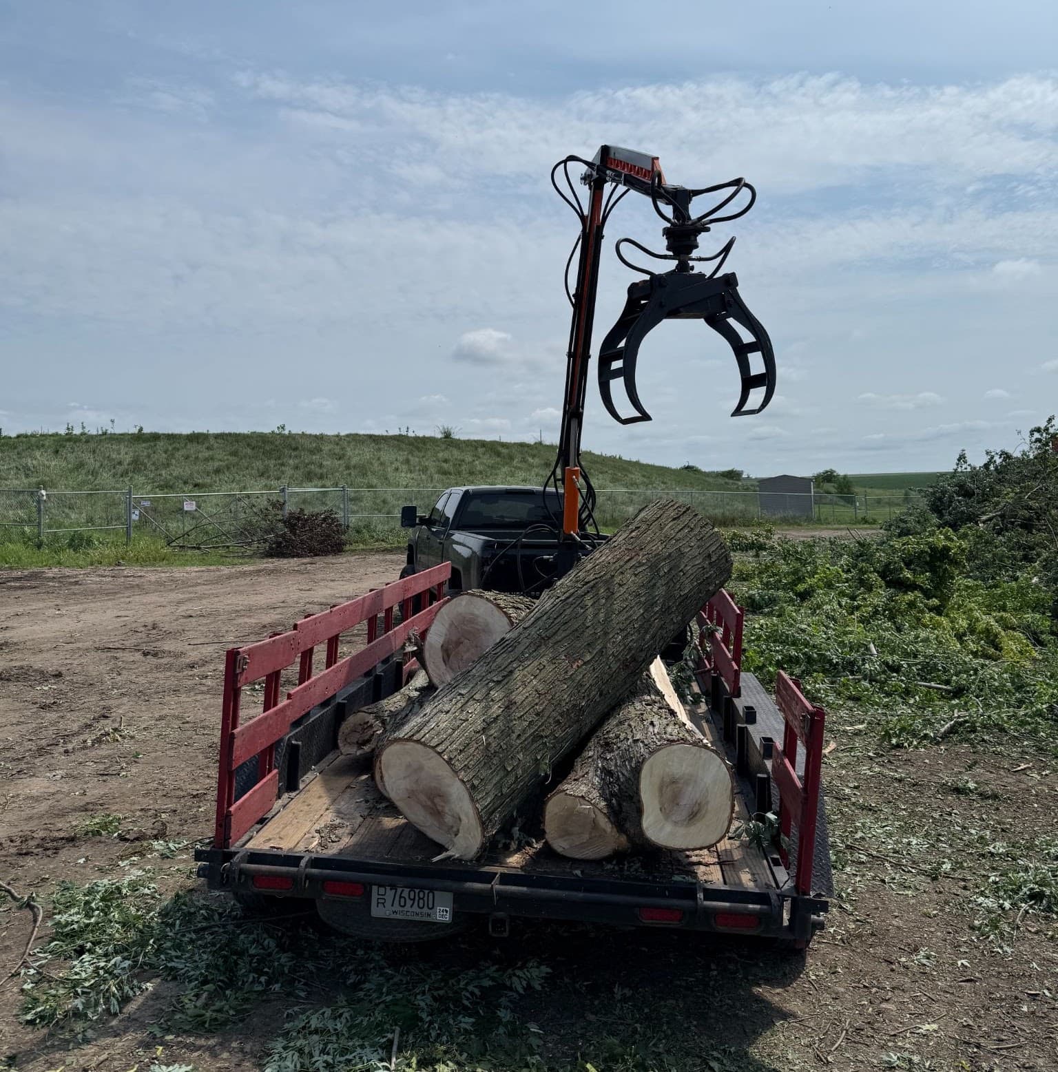 The Mulder Tree Service grapple truck loading heavy logs onto the trailer at a removal