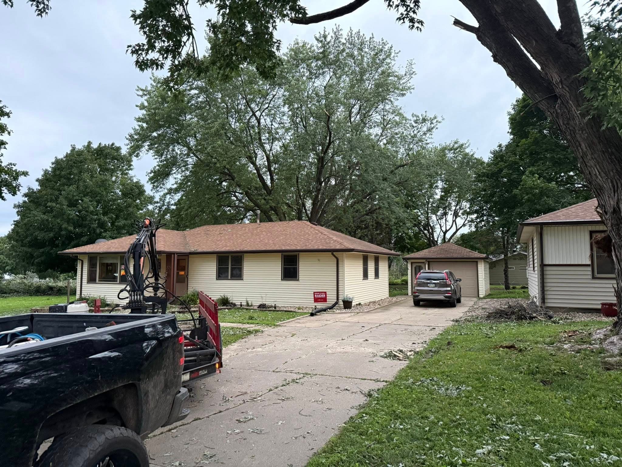 The grapple truck staged in a driveway ready to load storm debris